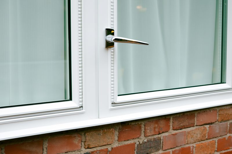 Close-up of a white uPVC casement window with chrome handle and beaded frame