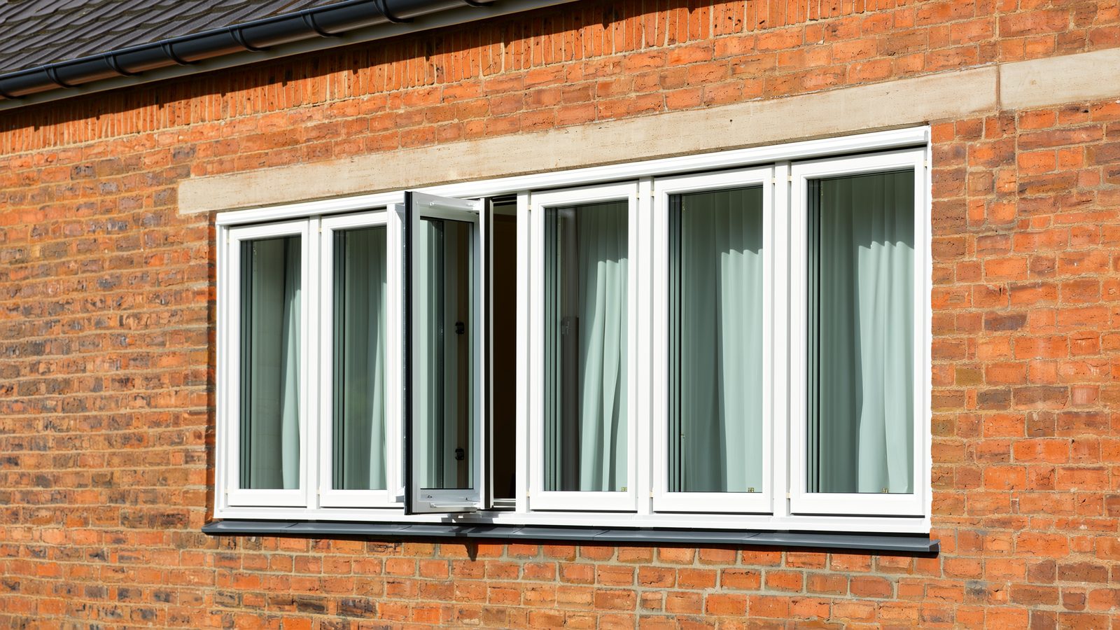 White uPVC casement windows on an English brick home